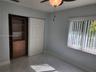 Room featuring large-format tile flooring, a custom-built wood closet system with integrated shelving and drawers, a ceiling fan with integrated light
