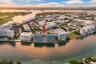 Waterfront mid-rise building featuring a rooftop pool, expansive balcony terraces, and direct canal access