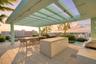 Rooftop terrace featuring a structural pergola, stone-paver flooring, built-in kitchen island, and integrated grilling station