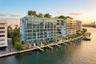 Waterfront residential complex featuring multiple levels of glass-railed balconies, a rooftop terrace, private deep-water dockage, and expansive floor