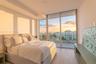 Floor-to-ceiling windows, private balcony, wood-finish flooring, and minimalist architectural lines