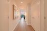 Interior hallway featuring wood-finish flooring, recessed ceiling lighting, and floor-to-ceiling double-door closets with satin-finish hardware
