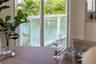 Large sliding glass door with white frame and water-front scenery featuring palms and a white railing