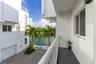 Private balcony with tile flooring and glass railings, featuring a paved driveway, exterior stucco facade, and waterfront canal access