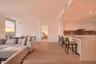 Open-concept interior featuring light wood-finish flooring, a kitchen with flat-panel cabinetry, a waterfall-edge countertop island, and recessed ceil