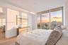 Floor-to-ceiling windows, private balcony, wood-finish flooring, and neutral wall tones