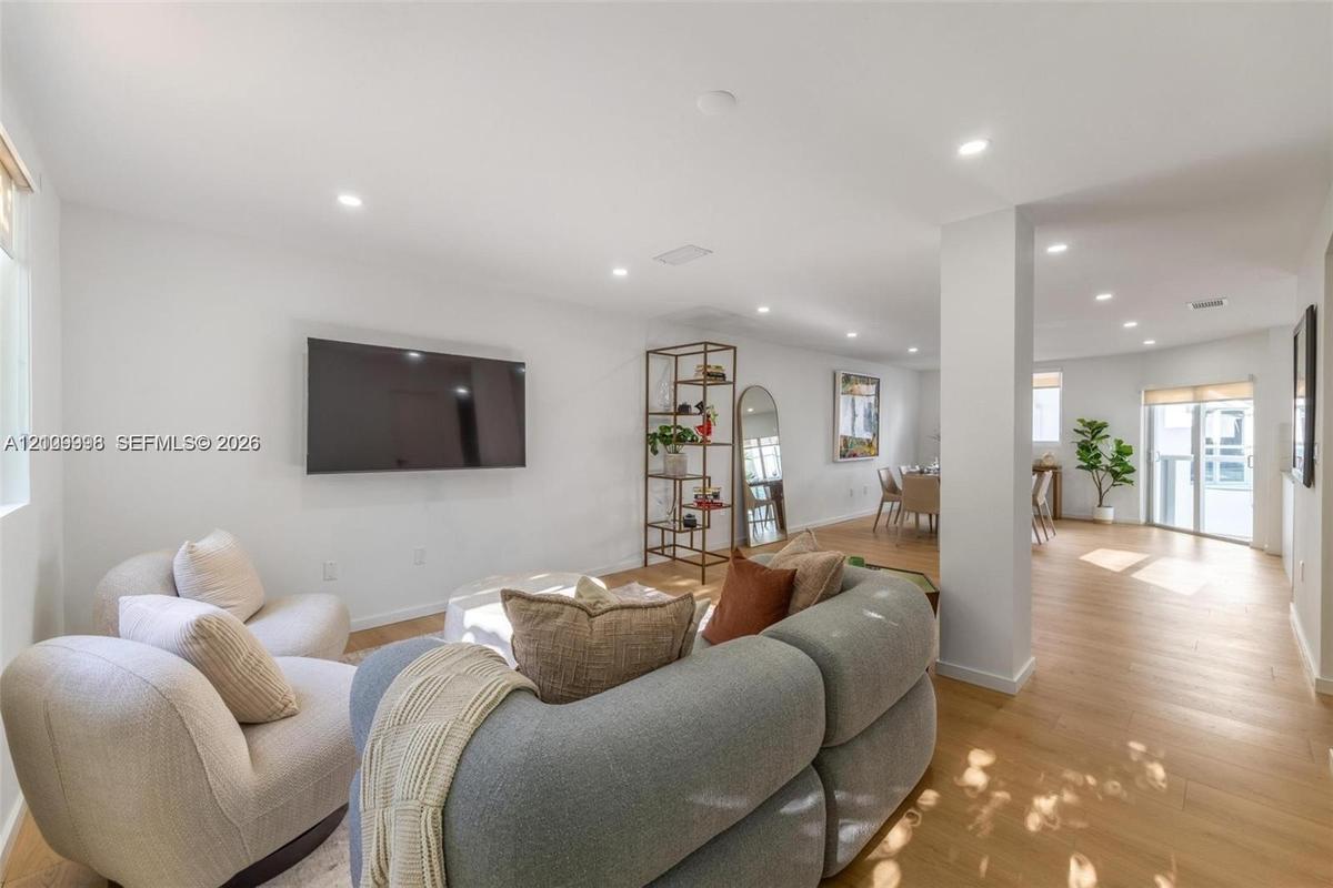 Open-concept interior featuring wood-finish flooring, recessed lighting, and expansive wall space