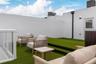 Rooftop terrace featuring tiered synthetic turf flooring, privacy perimeter walls, and a glass-panel railing