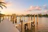 Waterfront dock featuring composite decking, vertical wood pilings, and multiple slips