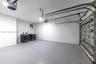 Enclosed garage featuring finished concrete flooring, overhead automatic door opener, and side-by-side laundry appliances