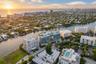 Aerial perspective featuring waterfront placement, proximity to the coastline, multi-story structural architecture, and rooftop recreational spaces