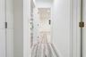 Interior hallway featuring neutral walls, wood-finish flooring, recessed lighting, and white door casings