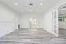 Wood-finish flooring, recessed lighting, and white-paned French doors