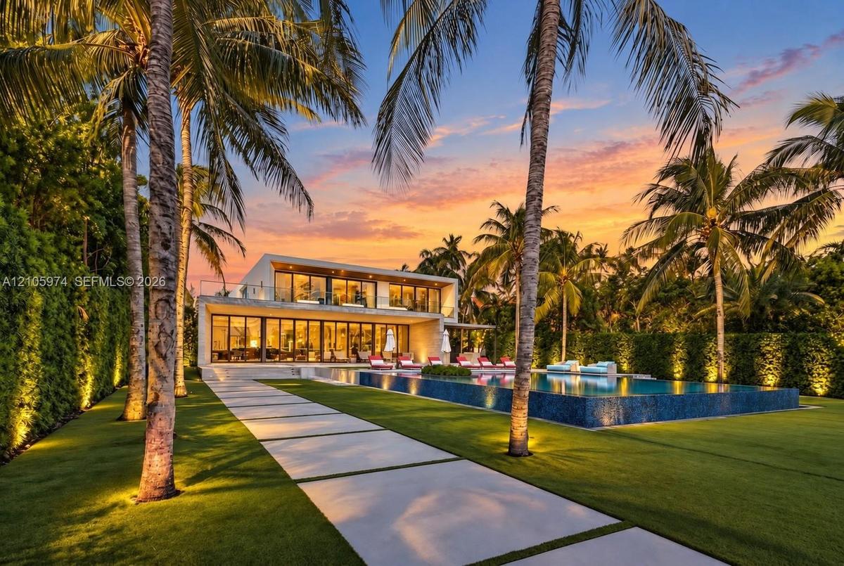 Modern architectural exterior featuring floor-to-ceiling glass wall systems, a second-story balcony with metal railings, a tiled infinity-edge pool, a