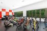 Expansive room featuring high-gloss red and white wall panels, durable rubberized diamond-plate flooring, and two sets of multi-panel aluminum-framed 