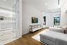 Wood-finish flooring, stone-clad bathroom surfaces, recessed ceiling lighting, and a glass-enclosed shower