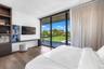 Floor-to-ceiling sliding glass doors, built-in floor-to-ceiling shelving, wood-finish flooring, and integrated wall-mounted desk