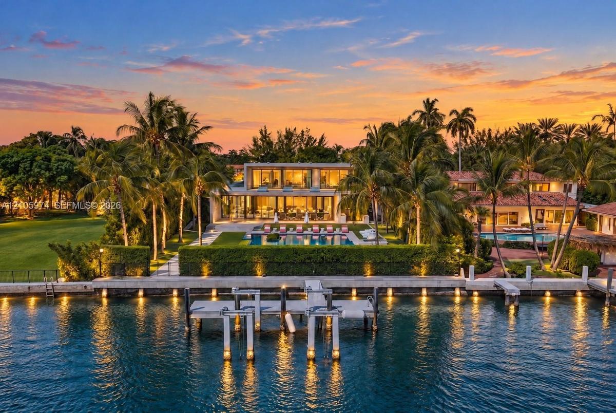 Waterfront estate featuring a deep-water dock, multi-level exterior architecture with floor-to-ceiling glass, an expansive swimming pool, and manicure