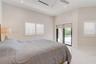 High-ceilinged room featuring polished stone-finish flooring, recessed lighting, white shuttered windows, and glass sliding doors
