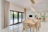 Open-concept interior featuring large-format polished tile flooring, floor-to-ceiling glass panel doors, a multi-light contemporary glass chandelier, 