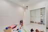 High-ceiling room with white stone-finish flooring and a built-in closet featuring integrated shelving and hanging rods