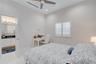 Room featuring white tile flooring, ceiling fan, recessed lighting, plantation shutters, and a bathroom with white cabinetry and a dark countertop