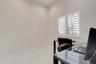 Neutral-toned interior featuring large-format tile flooring and window shutters