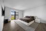 Floor-to-ceiling windows with dark framing, wood-finish flooring, and high ceilings