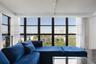 Floor-to-ceiling windows with dark-finish frames, wood-finish flooring, and track lighting