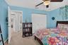 Bedroom featuring carpeted flooring, a ceiling fan with integrated lighting, and a closet with white louvered doors