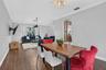 Open-concept area featuring wood-finish flooring, crown molding, a bay window, and a decorative chandelier