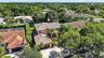 Two-story residence featuring a tile roof, stucco exterior, multi-car garage, and mature landscape