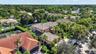 Aerial perspective featuring multi-level residences with tiled roofs, established landscaping, and paved driveways