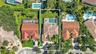 Aerial view of property featuring a tile roof, screen-enclosed pool, landscaped lawn, and paved driveway