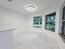 Large-format tile flooring, bay windows, and a modern circular chandelier fixture