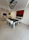 Large-format tile flooring, multi-tiered geometric pendant lighting, and crisp white wall finishes