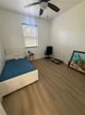 Room featuring wood-finish flooring, a neutral color palette, and a ceiling-mounted fan with integrated light fixture