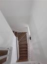 Staircase featuring wood-finish treads and a white painted balustrade