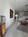 Interior area featuring large-format tile flooring, white wall finishes, a built-in staircase with a wooden handrail and white balusters, and recessed