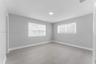 Neutral-toned interior space featuring wood-finish flooring, recessed lighting, and dual-pane windows with integrated light-filtering shades