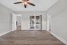 Interior space featuring wood-finish flooring, a ceiling fan with integrated lighting, and sliding glass doors