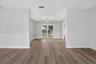 Interior space featuring wood-finish flooring, neutral wall tones, a geometric metal chandelier, and sliding glass doors