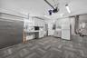 Garage featuring modular carpet tile flooring, built-in light-grey cabinetry, light-colored countertops, and integrated linear lighting