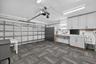 Garage space featuring modular tile flooring, built-in white cabinetry, stone-finish countertops, and a utility sink