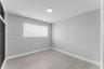 Room featuring wood-finish flooring, neutral wall paint, a flush-mount ceiling light, and louvered-style closet doors
