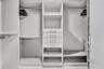 Custom closet system with multiple shelving units, integrated drawers, and chrome hanging rods