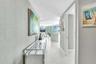 Hallway featuring textured wall coverings, recessed lighting, and white tile flooring