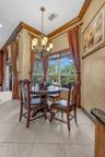 Large-format tile flooring, multi-pane windows, ornate metal chandelier, and detailed crown molding