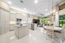 Kitchen featuring white cabinetry, stone countertops, a center island, stainless steel appliances, and tile flooring