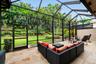 Screened-in patio enclosure featuring stone flooring and metal structural framing